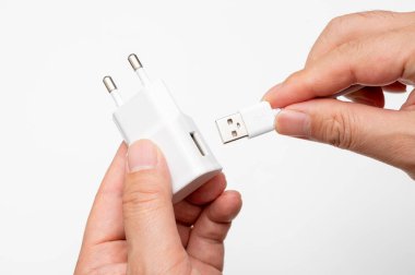 Erkek el USB kablosunu şarj eden adaptöre bağlıyor.