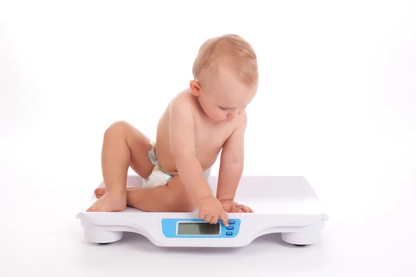 Baby boy check own weight on scales — Stock Photo, Image