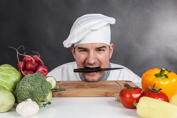 有趣的年轻厨师用刀和蔬菜 — 图库照片