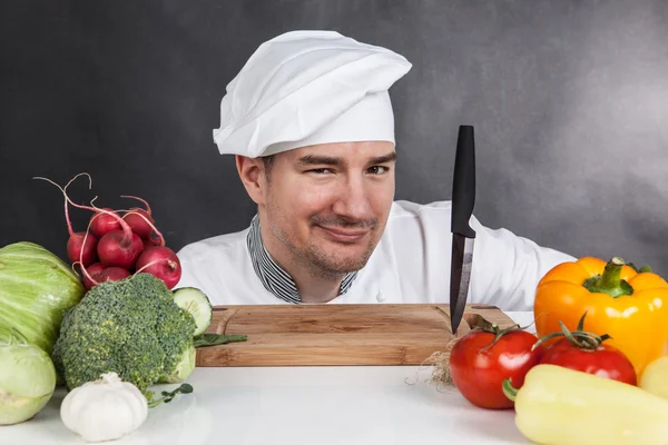 Giovane chef con coltello e verdure — Foto Stock