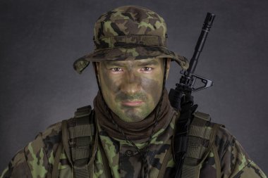 Orman kamuflaj boya ile genç asker.