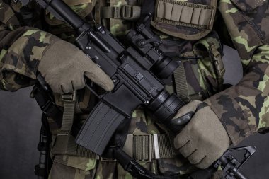Detail of a soldier holding modern weapon M4 clipart