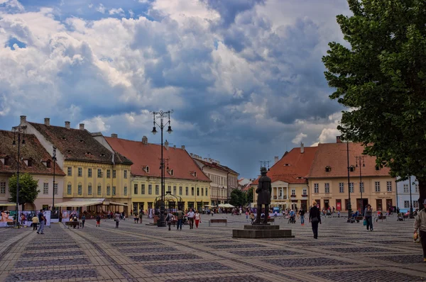 SIBIU, RUMANIA - 08 DE JUNIO DE 2014: Los turistas visitan la plaza principal en Sibiu, Rumania. Sibiu fue designada Capital Europea de la Cultura para el año 2007 — Foto de Stock