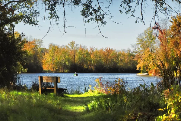 俯瞰塞内卡河的长椅 通往纽约利物浦奥农达加湖公园的奥农达加湖 远处有一个渔夫正在钓鱼 — 图库照片