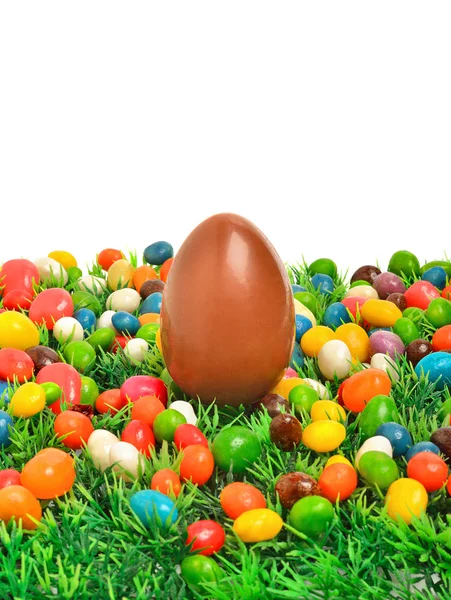 Easter chocolate egg and caramels on the green grass — Stock Photo, Image