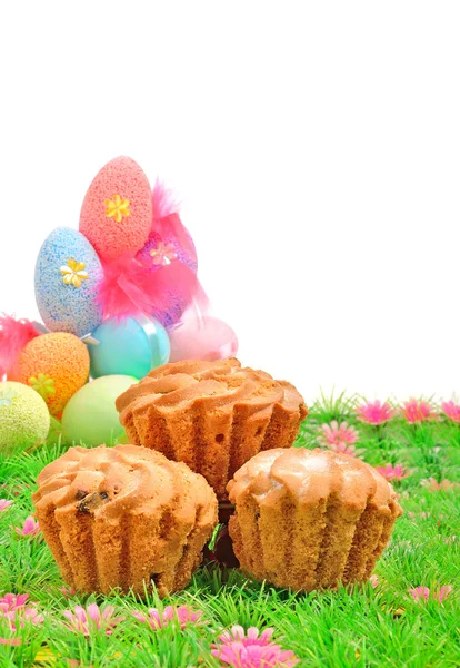Velikonoční dorty a barevné vejce na zelené trávě — Stock fotografie