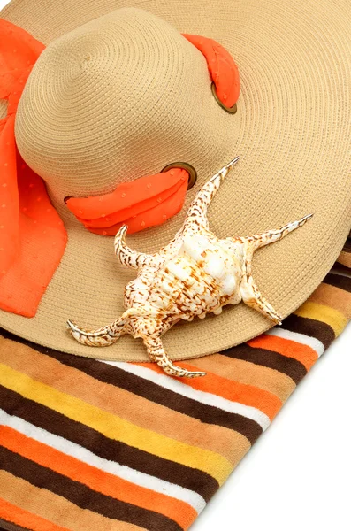 Plaj şapka, parlak bir havlu ve bir deniz kabuğu — Stok fotoğraf