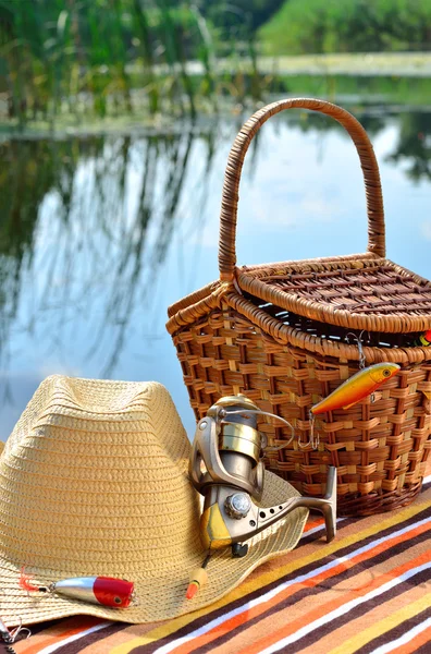 Cowboy hat, wicker basket, spool and fishing tackle in the nature — Stock Photo, Image