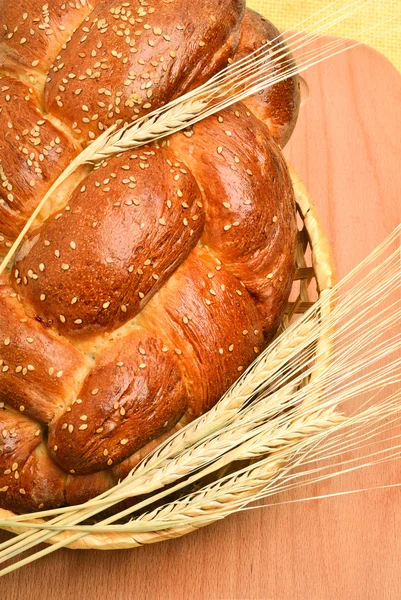 Fresh bread and wheat on the wooden board — Stock Photo, Image