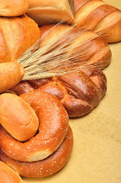 Pane fresco e spiga di grano sulla tovaglia — Foto Stock