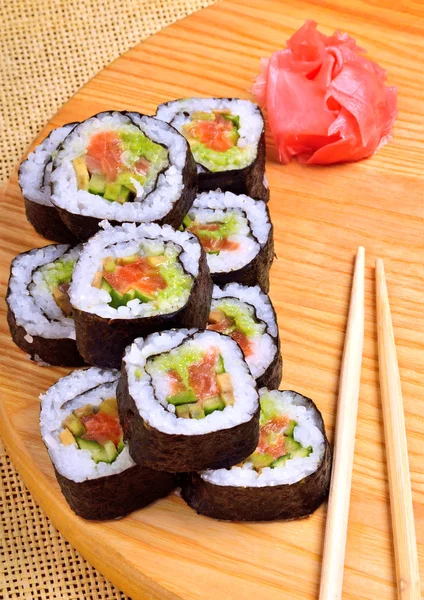 Sushi, Rollen, Ingwer und Essstäbchen auf Bambusmatte — Stockfoto