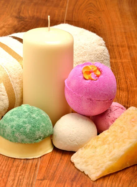 Candle, soap, bath bombs and bath towel on the wooden background — Stock Photo, Image