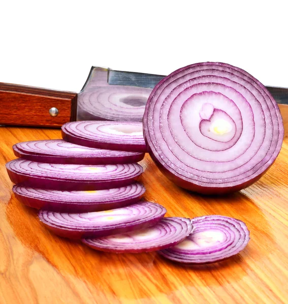 Cebolla roja en rodajas y un cuchillo en la mesa de madera —  Fotos de Stock