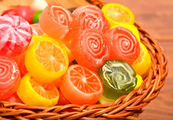 Dulces brillantes, piruletas, jaleas en la cesta en la madera —  Fotos de Stock