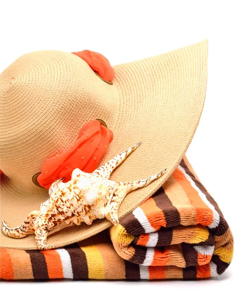 Woman beach hat, bright towel and a seashel — Stock Photo, Image