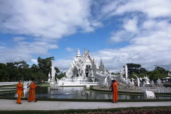 Buddhistiska munkar, vitt tempel och moderna prylar. — Stockfoto