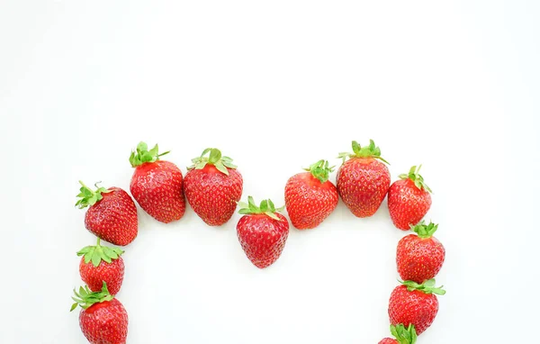 Strawberries in the shape of half a heart on a white background — Stock Photo, Image