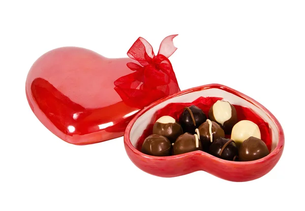 Chocolate candies in heart shaped box with red ribbon — Stock Photo, Image