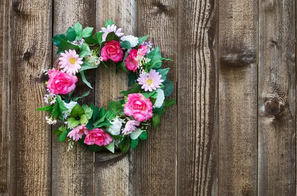 Floral wreath on fence — Stock Photo, Image