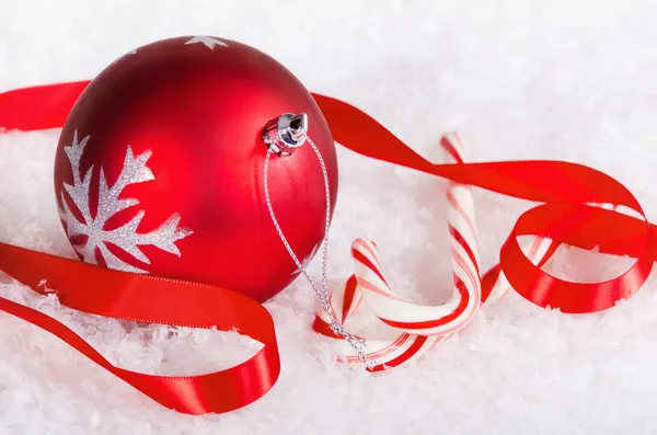 Zuckerstangen und eine rote Weihnachtskugel — Stockfoto