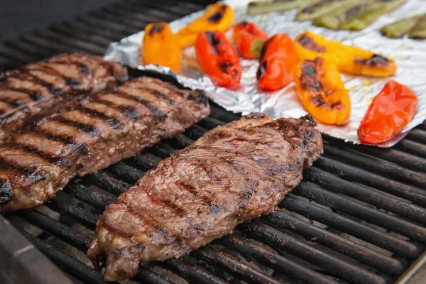 Steaks and peppers cooking on the grill — Stock Photo, Image