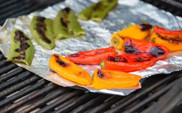 Grilling colorful peppers on foil — Stock Photo, Image