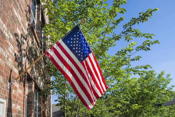 Drapeau américain devant une maison en brique — Photo