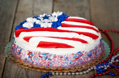 Vatansever kırmızı, beyaz ve mavi, ahşap arka planda bayrak şeklinde boncuklu Amerikan bayrağı pastası. Anma Günü, 4 Temmuz, Bağımsızlık Günü, Bayrak Günü teması.