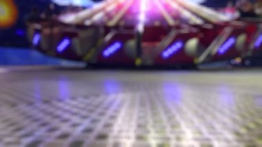 Joyful and Colorful Blurry Amusement Park Fun Fair at Night 