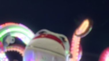 Joyful and Colorful Blurry Amusement Park Fun Fair at Night 