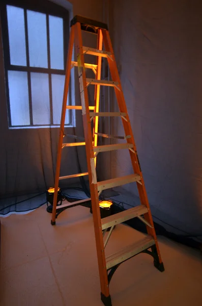 Stepladder fica perto de uma janela — Fotografia de Stock