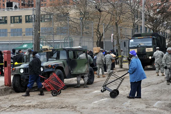 BROOKLYN, NY - 01 DE NOVIEMBRE: El ejército estadounidense ayuda a la gente en el barrio de Seagate con agua y alimentos debido al impacto del huracán Sandy en Brooklyn, Nueva York, EE.UU., el jueves 01 de noviembre de 2012 . —  Fotos de Stock