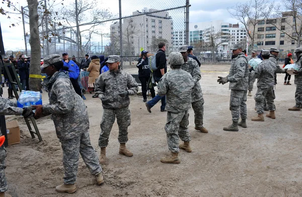 BROOKLYN, NY - 01 DE NOVIEMBRE: El ejército estadounidense ayuda a la gente en el barrio de Seagate con agua y alimentos debido al impacto del huracán Sandy en Brooklyn, Nueva York, EE.UU., el jueves 01 de noviembre de 2012 . —  Fotos de Stock