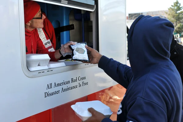 NEW YORK, NY - NOVEMBER 09: collects hot lunches from a mobile Red Cross feeding unit in the Breezy Point part of Far Rockaway on November 9, 2012 in the Queens borough of New York City. — Stock Photo, Image