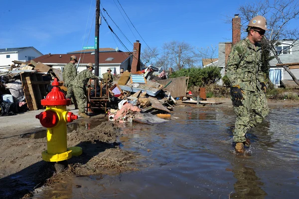 New york, ny - november 09: Amerikaanse mariniers verplaatsen een puin en delen van verwoeste huizen in de winderige punt deel van far rockaway op 9 november 2012 in de borough queens van New York — Stockfoto