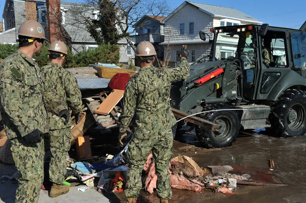 New york, ny - november 09: Amerikaanse mariniers verplaatsen een puin en delen van verwoeste huizen in de winderige punt deel van far rockaway op 9 november 2012 in de borough queens van New York — Stockfoto