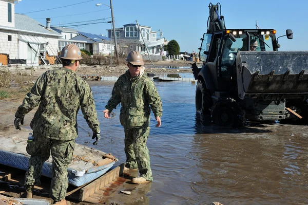 New york, ny - november 09: Amerikaanse mariniers verplaatsen een puin en delen van verwoeste huizen in de winderige punt deel van far rockaway op 9 november 2012 in de borough queens van New York — Stockfoto