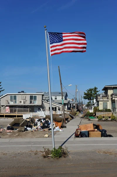 NEW YORK, NY - NOVEMBER 09: An American flag flies from the front yard of a house in a damaged area November 9, 2012 in the Breezy Point part of Far Rockaway in the Queens borough of NY. — Stock Photo, Image