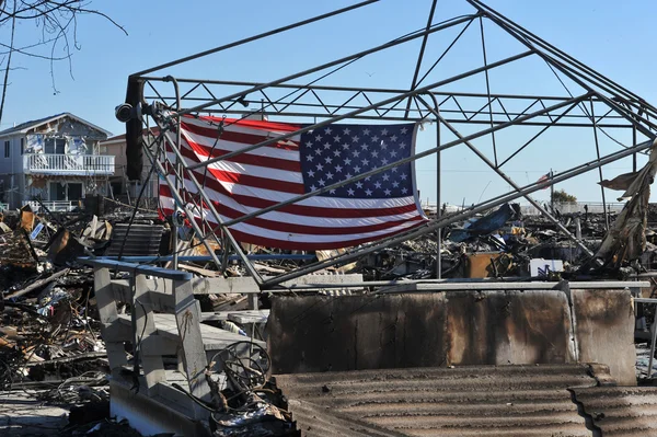 NOVA IORQUE, NY - NOVEMBRO 09: Uma bandeira rasgada americana voa do jardim da frente de uma casa em uma área danificada 9 de novembro de 2012 na parte Breezy Point de Far Rockaway, no distrito de Queens, NY . — Fotografia de Stock