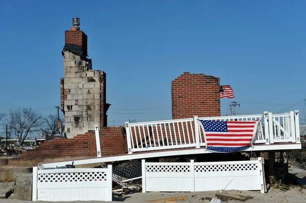 NEW YORK, NY - 09 NOVEMBRE : Un drapeau américain flotte de la maison brûlée dans une zone endommagée Le 9 novembre 2012 dans la partie Breezy Point de Far Rockaway dans l'arrondissement Queens de NY . — Photo