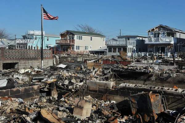 New york, ny - november 09: een Amerikaanse vlag vliegt van het verbrande huis in een beschadigd gebied het luchtig punt deel van far rockaway in de borough queens van New York, 9 november 2012. — Stockfoto