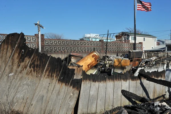 NEW YORK, NY - 09 NOVEMBRE: Una bandiera americana sventola dalla casa bruciata in un'area danneggiata 9 novembre 2012 nella parte di Breezy Point di Far Rockaway nel quartiere Queens di NY . — Foto Stock