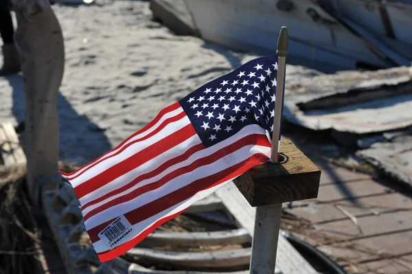 НЬЮ-ЙОРК, Нью-Йорк - 9 НОЯБРЯ: Американский флаг вывешивается из сгоревшего дома в поврежденном районе 9 ноября 2012 года в районе Бризи-Пойнт в районе Far Rockaway в районе Куинс штата Нью-Йорк . — стоковое фото