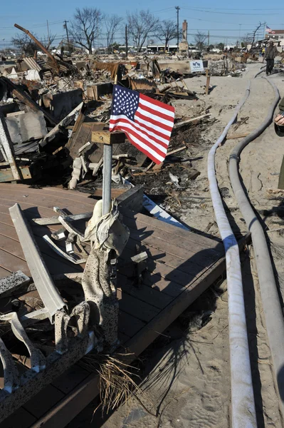 NUEVA YORK, NY - 09 DE NOVIEMBRE: Una bandera estadounidense ondea desde la casa quemada en un área dañada 9 de noviembre de 2012 en la parte Breezy Point de Far Rockaway en el distrito Queens de NY . —  Fotos de Stock