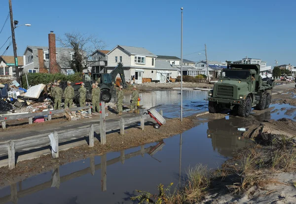 New york, ny - november 09: US marines flytta en skräp och delar av förstörda hus i den blåsiga punkt delen av långt rockaway på 9 november 2012 i stadsdelen queens ny — Stockfoto