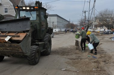 Queens, ny - 11 Kasım: Rockaway'de kum temizleme gönüllüler, 11 Kasım 2012 tarihinde queens, new york, ABD, kumlu kasırga sonra yerleşim bölgesinde plaj.