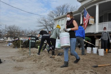 Queens, ny - 11 Kasım: Rockaway'de kum temizleme gönüllüler, 11 Kasım 2012 tarihinde queens, new york, ABD, kumlu kasırga sonra yerleşim bölgesinde plaj.