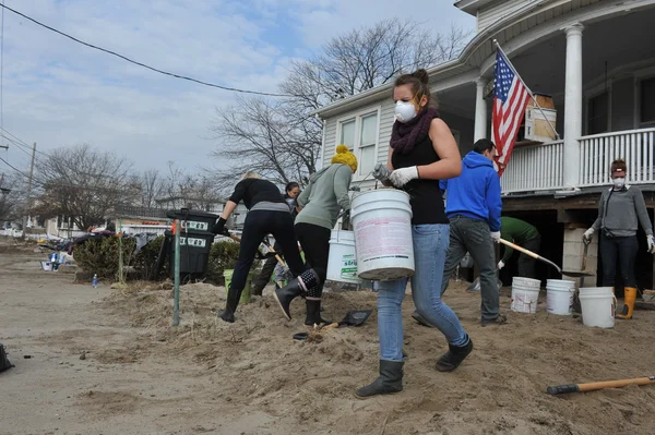 Queens, ny - 11 Kasım: Rockaway'de kum temizleme gönüllüler, 11 Kasım 2012 tarihinde queens, new york, ABD, kumlu kasırga sonra yerleşim bölgesinde plaj.