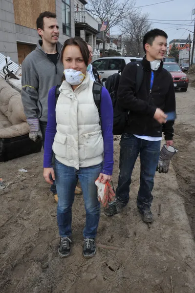 QUEENS, NY - 11 NOVEMBRE : Des bénévoles nettoient le sable dans le quartier résidentiel de Rockaway Beach après l'ouragan Sandy dans le Queens, New York, États-Unis, le 11 novembre 2012 . — Photo