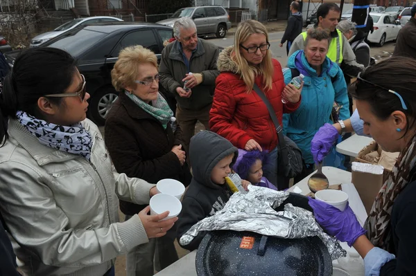 Queens, ny - 11 Kasım: Giysi ve malzemeleri rockaway plaj alanı 11 Kasım 2012 tarihinde kasırga queens, new york, ABD, kumlu gelen darbe sonrası sıcak yemek, ilgili yardım alma. — Stok fotoğraf